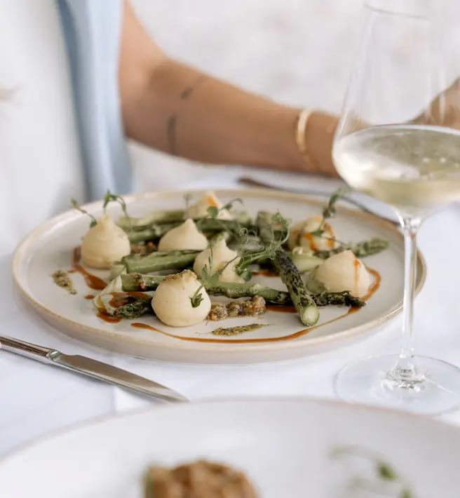 Fine dining at Schlosswirt zu Anif (c) Gassner Gastronomie, HECHTFISCH White plate with green asparagus at the Schlosswirt in Anif (c) Photo: Gassner Gastronomie, HECHTFISCH