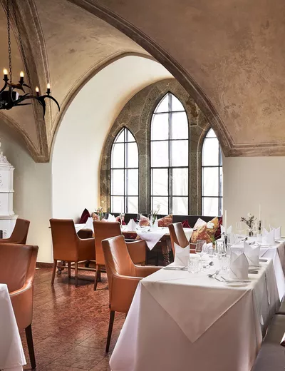 Set tables in the Gothic Room, the gourmet restaurant at Schloss Mittersill in Salzburger Land