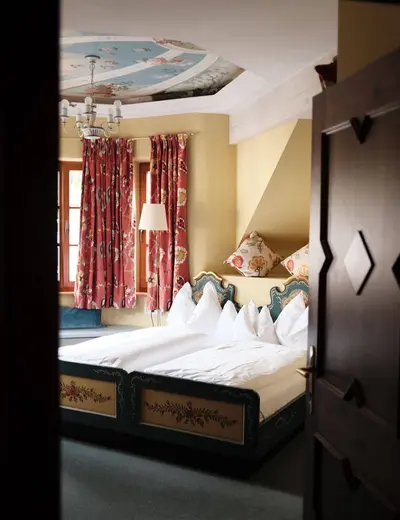 Das Bergschlössl (c) Schlosshotels & Herrenhäuser, Cornelius Klimt View through a doorway to a double bed at the Bergschlössl in St. Anton am Arlberg (c) photo Schlosshotels & Herrenhäuser, Cornelius Klimt