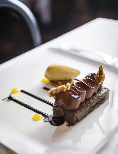 Artistically prepared chocolate creation on a white dessert plate at Boutique & Gourmet Hotel Orso Grigio, Innichen, South Tyrol