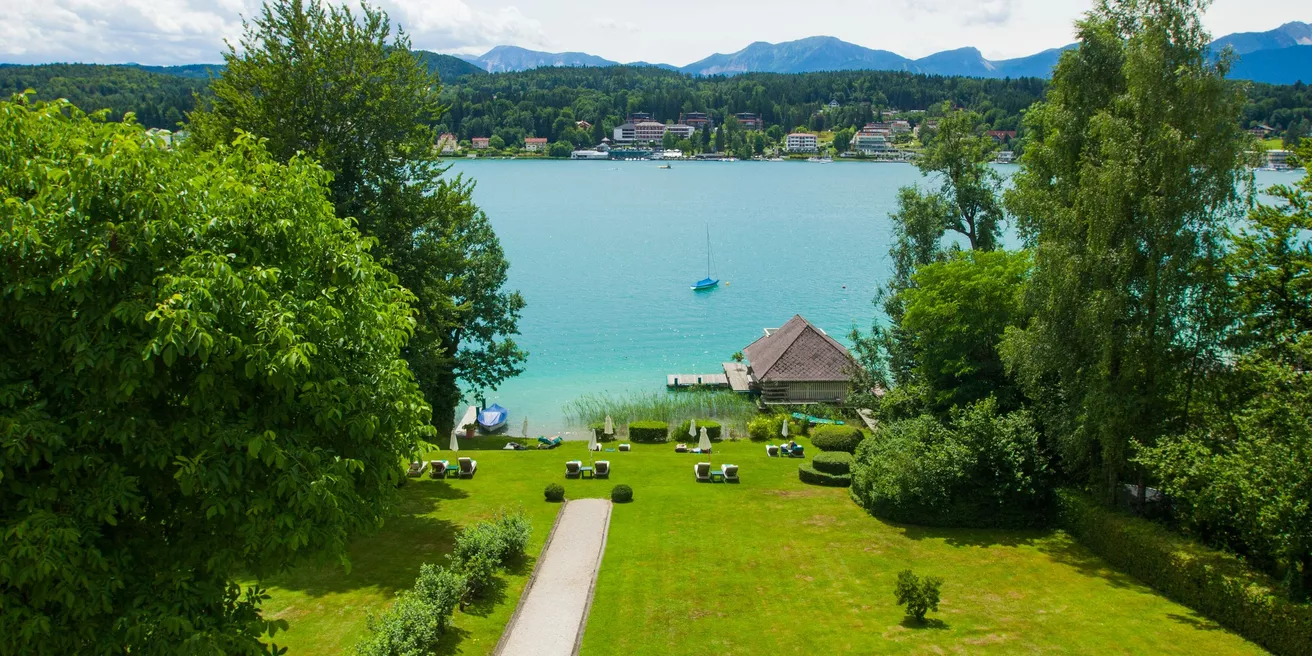 View from the Seeschlössl over the sunbathing lawn to the bathhouse and Lake Wörthersee
