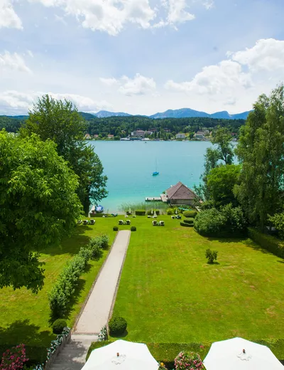 View from Seeschlössl Velden across the sunbathing lawn to the bathhouse in Lake Wörthersee