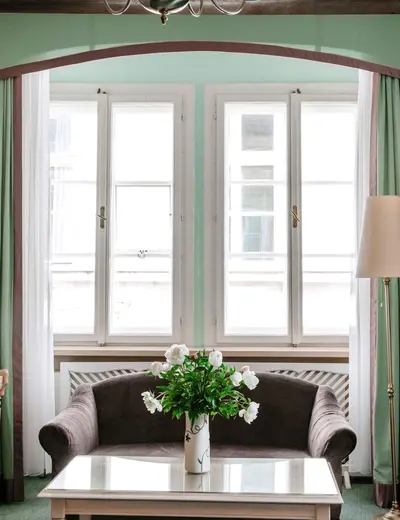 Double room (c) Hotel König von Ungarn View across a coffee table and a small couch toward the window in a mint-colored double room at the Hotel König von Ungarn in Vienna (c) Photo: Hotel König von Ungarn