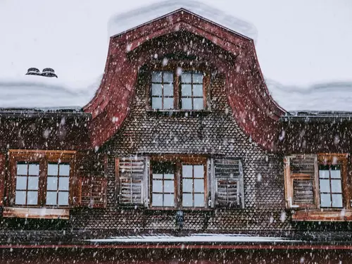 Shingle-covered exterior façade of the Hotel Gasthof Hirschen in Schwarzenberg during snowfall (c) Photo Hotel Gasthof Hirschen