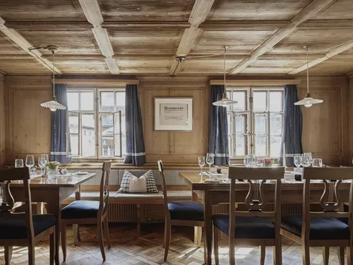 Set tables in the wood-paneled dining room of restaurant Gasthof Hirschen Schwarzenberg in Bregenzerwald (c) photo Adolf Bereuter.