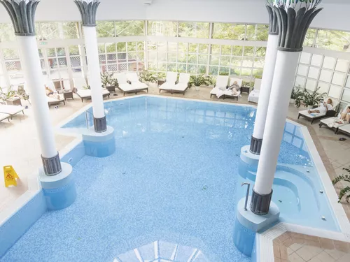 Indoor Pool surrounded by pillars and lounge chairs at Schlosshotel Szidónia (c) photo Schlosshotel Szidónia