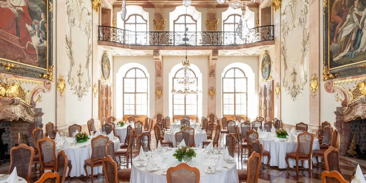 Marmorsaal mit festlich gedeckten runden Tischen im Schloss Leopoldskron in Salzburg