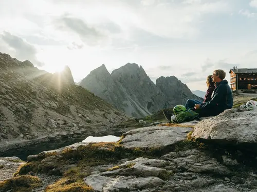 Karlsbaderhütte, hiking in East Tyrol (c) TVB Osttirol Couple in front of the Karlsbaderhütte with a view of the impressive mountain landscape (c) Photo TVB Osttirol