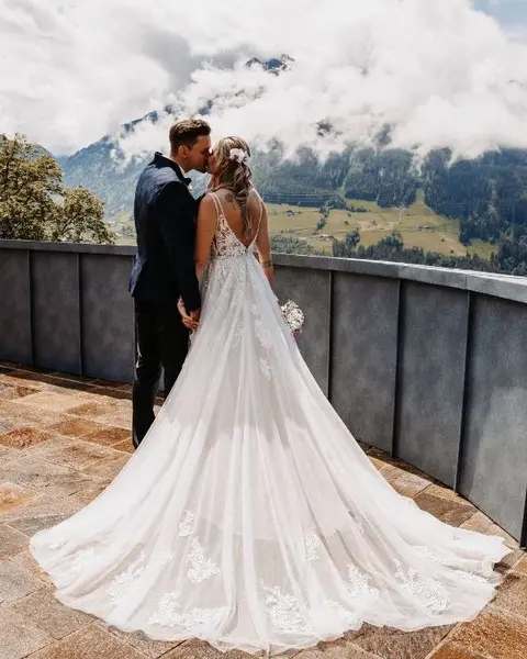 Küssendes Brautpaar auf der Terrasse vom Schloss Mittersill mit nebelverhangenen Bergen im Hintergrund (c) Foto Jasmin Haas Weddings