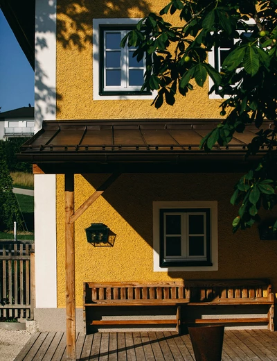 Gelbe Aussenfassade vom Stiegl-Gut Wildshut in der Sonne (c) Schlosshotels & Herrenhäuser