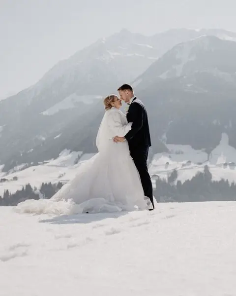 Brautpaar im Schnee mit Panoramaausblick, Schloss Mittersill (c) Foto Marco Palmer Photography