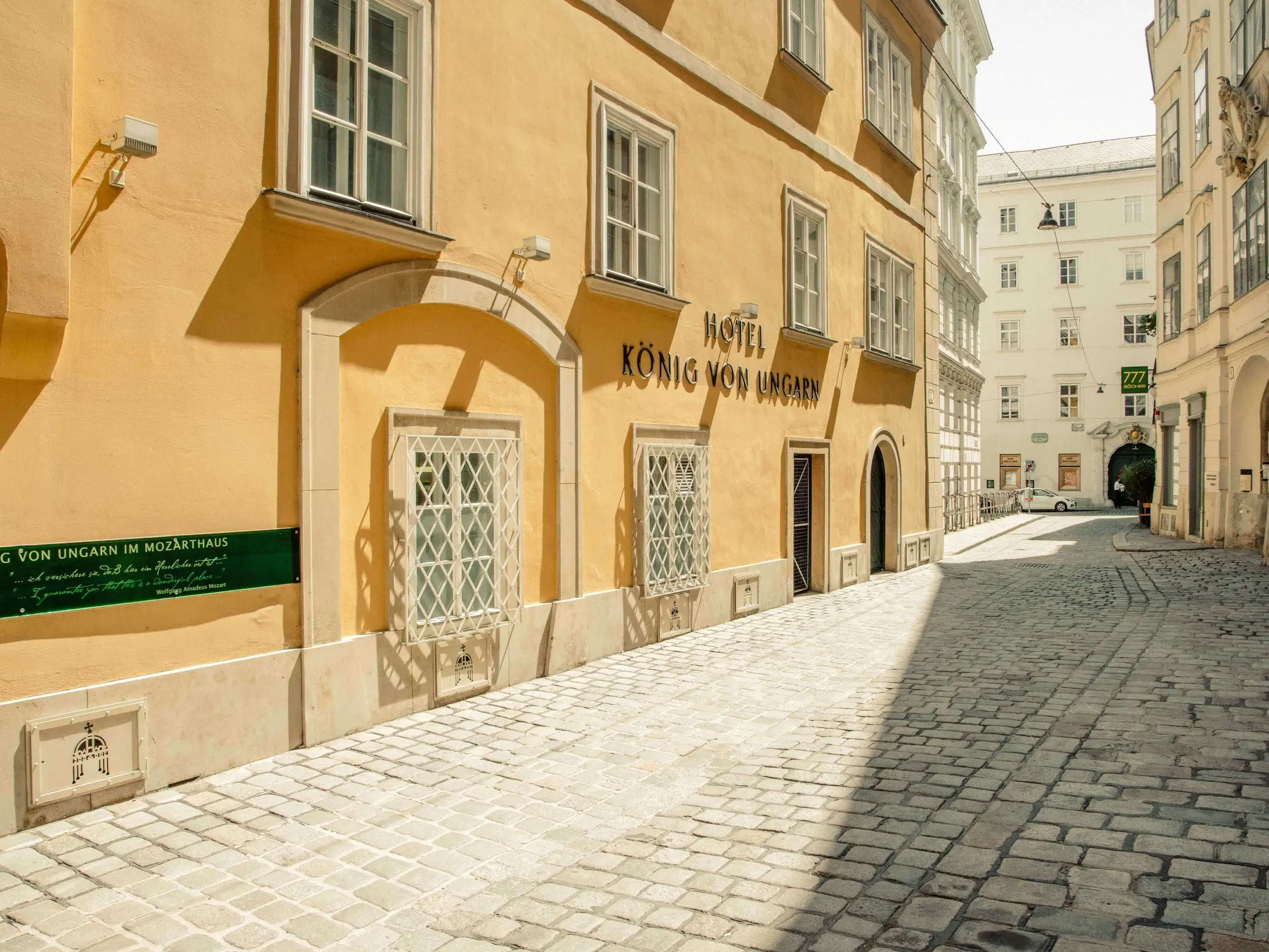 (c) Hotel König von Ungarn The yellow-painted facade of the Hotel König von Ungarn in Vienna, looking down the deserted, cobblestone street (c) Photo: Hotel König von Ungarn
