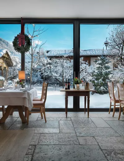 Schön gedeckte Tische im Wintergarten vom Hotel Landgasthof Linde in Stumm mit grosser Fensterfront und Blick auf den verschneiten Garten (c) Heli Hinkel