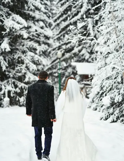 Bridal couple strolls along a snowy forest path (c) photo Konstantin Mishchenko / Unsplash