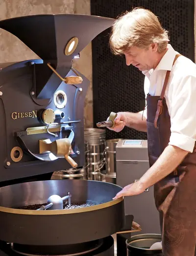 Host Alexander Drastil roasting coffee in the in-house coffee roastery (c) photo Platzhirsch Kufstein