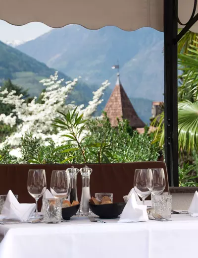 A beautifully laid table on the terrace of Hotel Castel Rundegg in Merano looking out on the mountains of South Tyrol 