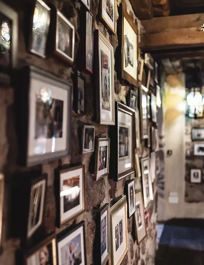 Wall at Schloss Hotel Korb in Missian, South Tyrol, with numerous small, framed pictures (c) photo Social Ventures